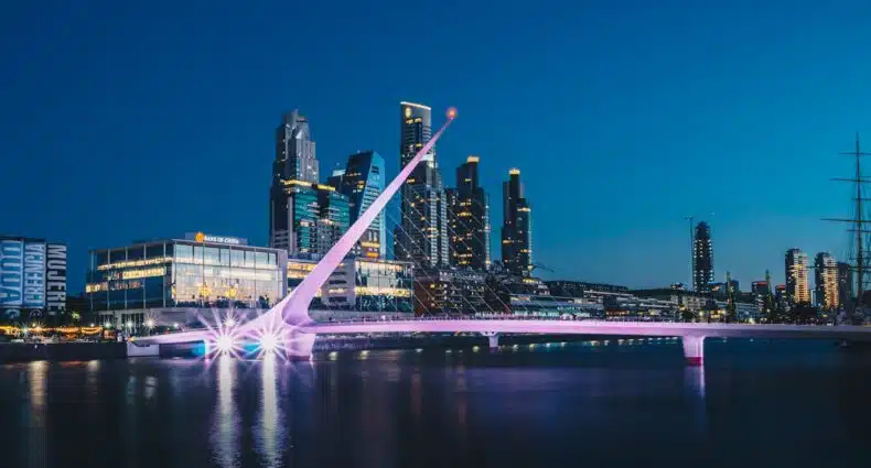 Ponte iluminada em Puerto Madero, em Buenos Aires, com skyline noturno e prédios modernos ao fundo