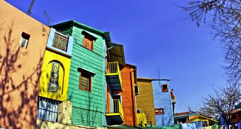 Casas coloridas em Caminito, Buenos Aires, com fachadas vibrantes em tons de verde, laranja, azul e rosa