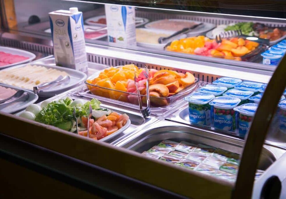 Buffet de café da manhã do Hotel Solaris com frutas frescas, iogurtes, sucos de soja e pães em exposição refrigerada. Essa é uma das indicações de onde ficar em Setúbal.