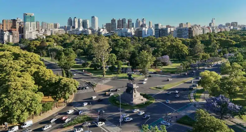 Praça em centro de cidade com monumento equestre, carros e prédios modernos ao fundo, em Palermo em Buenos Aires