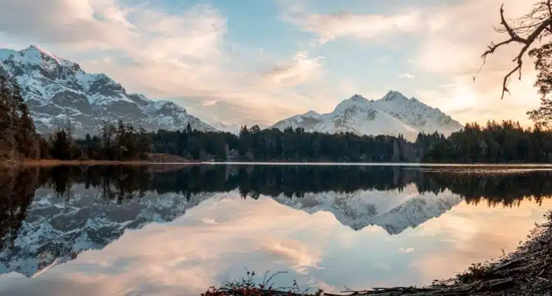 Paisagem com montanhas nevadas refletidas em lago calmo ao amanhecer na natureza em Bariloche.